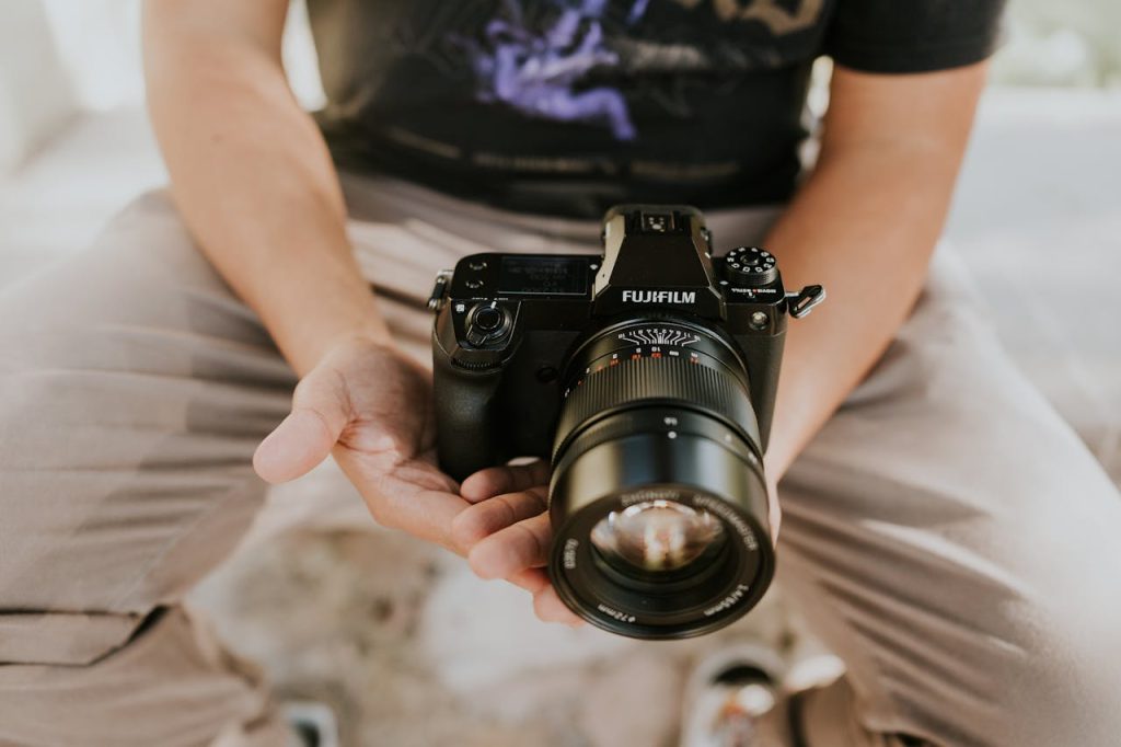 Close-up of a person holding a camera outdoors. Urban setting in León, Guanajuato.